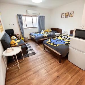 a room with two beds and a couch and a table at 林林の民宿-関空直達、minion room 小黄人主题房 in Osaka