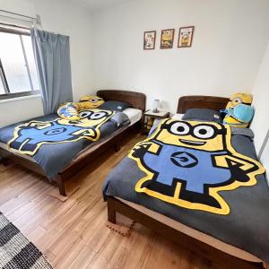 a bedroom with two beds with a mask on them at 林林の民宿-関空直達、minion room 小黄人主题房 in Osaka