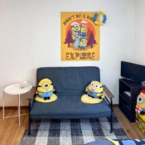a childs room with a blue couch with a tv at 林林の民宿-関空直達、minion room 小黄人主题房 in Osaka