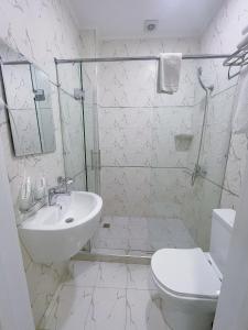 een witte badkamer met een douche en een wastafel bij Moffah Grand Hotel 美华酒店 in Tasjkent