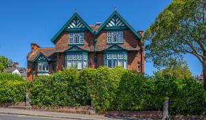 a red brick house with a green roof at Silversprings - City Centre Apartments with Parking in Exeter
