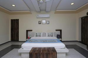 a bedroom with a large bed and a wooden table at Hotel Greenland in Udaipur
