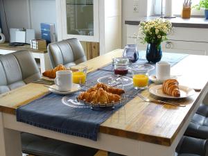 - Mesa con desayuno de cruasanes y zumo de naranja en Gode Wind Quartiere 6, en Dahme