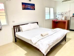 ein Schlafzimmer mit einem Bett mit weißen Laken und Kissen in der Unterkunft Khum Khun Phon Resort Khao Yai in Nong Nam Daeng