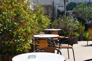 un gruppo di tavoli e sedie in giardino di Be My Guest Athens ad Atene