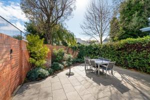 Abbys Beach Villa في Broadwater: طاولة وكراسي على فناء