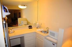 a bathroom with a sink and a mirror at Boarders Inn and Suites by Cobblestone Lamar Missouri in Lamar +33 photos
