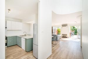 Abbys Beach Villa في Broadwater: مطبخ مفتوح وغرفة طعام مع دواليب زرقاء