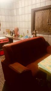 a kitchen with a couch in the middle of a kitchen at Hostel Polansk in São Thomé das Letras