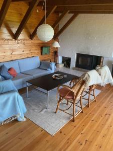 ein Wohnzimmer mit einem blauen Sofa und einem Tisch in der Unterkunft Cozy Summer House In The First Row To The Water, in Hornbæk