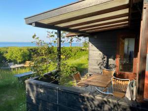 a patio with a table and chairs on a house at Cozy Summer House In The First Row To The Water, in Hornbæk