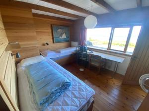 Zimmer mit einem Bett und einem Schreibtisch in einem Zimmer in der Unterkunft Cozy Summer House In The First Row To The Water, in Hornbæk