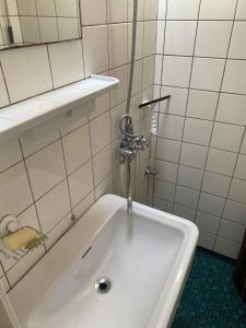 ein weißes Waschbecken im Bad mit einem Wasserhahn in der Unterkunft Cozy Summer House In The First Row To The Water, in Hornbæk