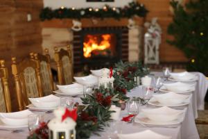 ein Tisch für ein Weihnachtsessen mit Kamin in der Unterkunft Hotel Kalchem in Brzozie