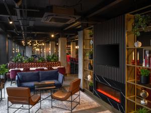 a lobby with a couch and chairs and a television at Radisson RED London Gatwick Airport in Crawley