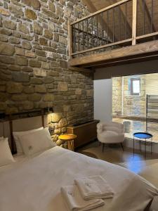 ein Schlafzimmer mit einem großen Bett und einer Ziegelwand in der Unterkunft Άνδηρο in Synikia Mesi Trikalon