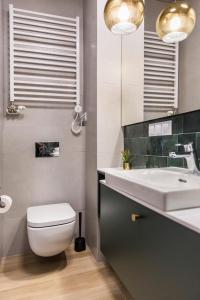 Łazienka z białą toaletą i umywalką w obiekcie Piedmont House w Krakowie