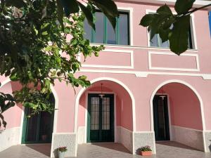 um edifício cor-de-rosa com arcos e janelas em Guest House Cifrino em Giffoni Sei Casali