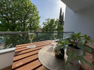 een tafel met twee wijnglazen en een plant op een balkon bij W&D living - FeWo Kleines Italien mit Parkplatz und Balkon in Celle
