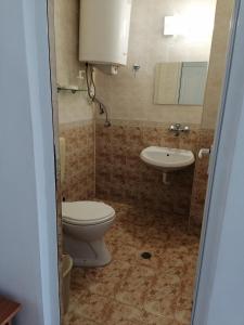 a bathroom with a toilet and a sink at Стаи за гости" Герови" in Nesebar +30 photos