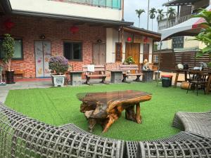 a wooden table sitting on top of green grass at Red brick 642 B&B in Puli