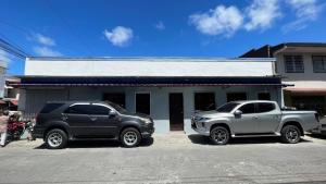 two cars parked in a parking lot in front of a building at Peaceful and Calm place in Lucena