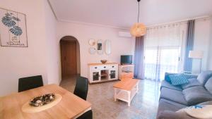 ein Wohnzimmer mit einem blauen Sofa und einem Tisch in der Unterkunft Apartamento muy cerca del mar. in Arenales del Sol