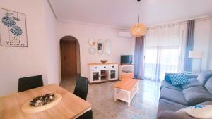 a living room with a blue couch and a table at Apartamento muy cerca del mar. in Arenales del Sol