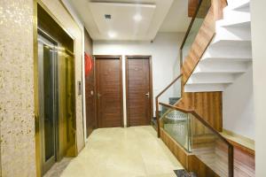 a hallway with a wooden door and stairs at FabExpress 56 Amritsar in Amritsar