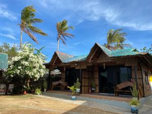 a house with palm trees in the background at Residencia Gemma in Siquijor