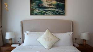 a bedroom with a white bed with a painting on the wall at City Chic: Elegant 1BR Apartment in Abu Dhabi