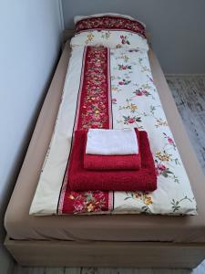 ein Bett mit roten und weißen Handtüchern darauf in der Unterkunft Apartament Warmiński - Old Town in Biskupiec