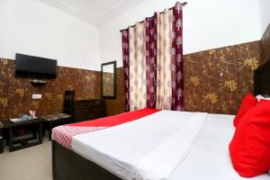 - une chambre avec un lit et une télévision dans l'établissement OYO Flagship 18943 Hotel Punjab Residency, à Banūr