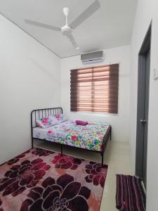 a small bedroom with a bed and a rug at Amaris Homestay in Sungai Petani