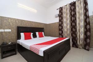 een slaapkamer met een groot bed met rode kussens bij OYO Flagship 18943 Hotel Punjab Residency in Banūr