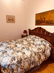 um quarto com uma cama com um edredão floral em Vila Romaneasca em Corbola