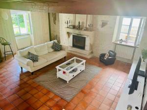ein Wohnzimmer mit einem Sofa und einem Kamin in der Unterkunft Maison très agréable et familiale Saintes Royan in La Jard