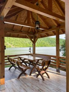 een houten tafel en bank op een houten terras bij Georgia Bahna in Orşova