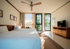 a bedroom with a large bed and a flat screen tv at Beachview 3BR Villa with private pool in Danang