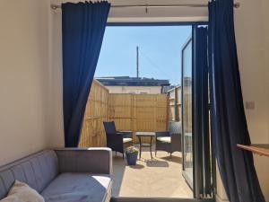 ein Wohnzimmer mit einem Sofa und einem Fenster in der Unterkunft Luxurious London Studios in Harrow