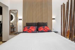 - une chambre avec un lit blanc et des roses rouges dans l'établissement Bambou Heliopolis, au Cap d'Agde