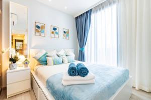 a bedroom with a bed with blue towels on it at Laguna Skypark by My Home Phuket in Bang Tao Beach +39 photos