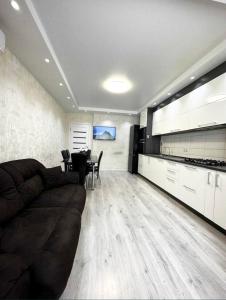 a living room with a brown couch and a table at Most City Area Pearl Apartment in Dnipro