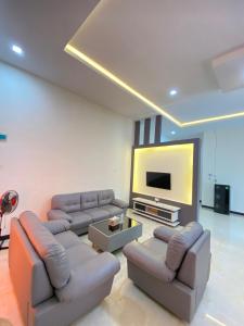 een woonkamer met banken en een flatscreen-tv bij Awandari Resort & Convention in Kangkakawal
