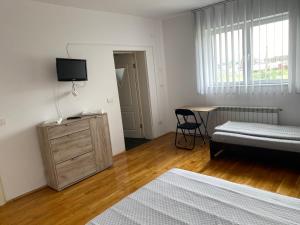 een slaapkamer met een bed, een bureau en een televisie bij Casa Erika in Sebeş