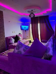 fioletowy pokój z kanapą i telewizorem w obiekcie Family Condo With Panoramic Sea View 1 w Aleksandrii