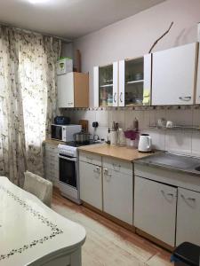 uma cozinha com armários brancos e uma bancada em Central Stay em Ulan Bator