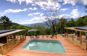 a pool on a wooden deck with a view of the mountains at Chalet U Pinu in Venaco +3 photos