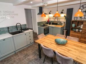 een keuken met een houten tafel en een kom erop bij Winterbrook Cottage in St Austell