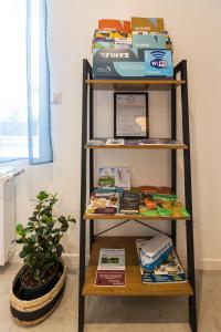 une étagère avec des livres et une plante en pot dans l'établissement La Longère Forézienne, à Sainte-Agathe-la-Bouteresse